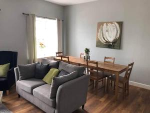 a living room with a couch and a wooden table at Meikle Farm Cottage in Westruther