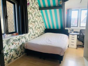 a bedroom with a bed with a striped wall at Topzomer in Sleat in Sloten