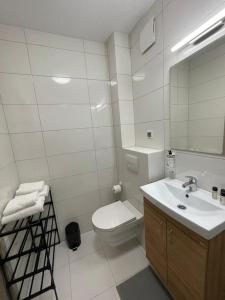 Baño blanco con aseo y lavamanos en Cyprysowa Fine Apartment en Varsovia