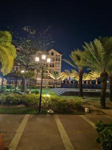 un bâtiment avec des palmiers dans un parc la nuit dans l'établissement Amalfi Oasis Condo near SM Seaside Cebu, à Cebu