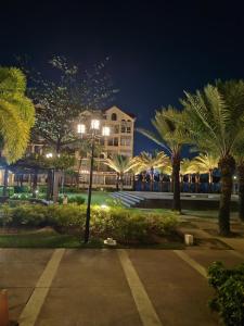 a building with palm trees in a park at night at Amalfi Oasis Condo near SM Seaside Cebu in Cebu City