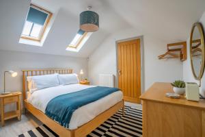 a bedroom with a bed and a desk and windows at The Smithy in York