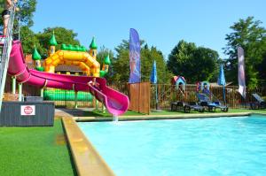 a pool with a water slide in a playground at Flower Camping Les Mijeannes in Rieux-de-Pelleport