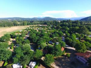 una vista aerea di una piccola città con alberi e montagne di Camping Les Mijeannes a Rieux-de-Pelleport