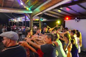 a group of people standing in a crowd at a party at Flower Camping Les Mijeannes in Rieux-de-Pelleport