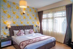 a bedroom with a bed with a floral wallpaper at Voyage Dreamvilla Retreat in Pelling