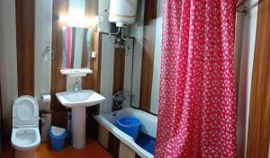 a bathroom with a red shower curtain and a sink at Srinagar hotels and houseboats in Srinagar