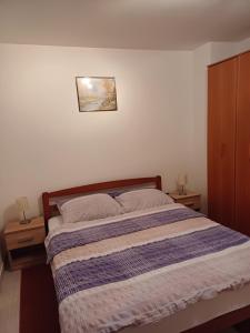 a bed in a bedroom with two nightstands at APARTMAN KOREN in Malinska