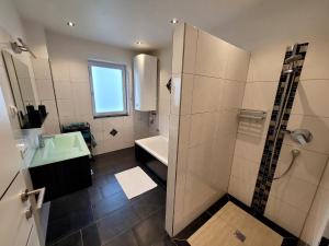 a bathroom with a shower and a sink and a tub at Apartment Schett in Neukirchen am Großvenediger