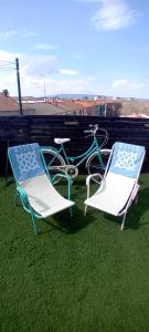 two chairs and a bike sitting next to a table and a chair at Atico en el centro de Vitoria Parking gratis in Vitoria-Gasteiz