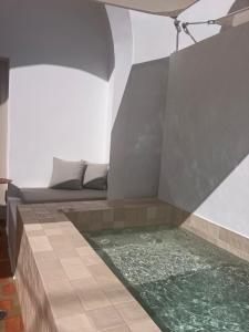 a room with a pool of water in the floor at Ethos Vegan Suites Fira, Santorini in Fira