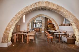 a restaurant with a stone archway and tables and chairs at Boutique Hotel Posada Terra Santa in Palma de Mallorca
