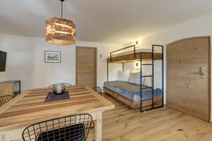 a bedroom with a bunk bed and a wooden table at Stube Biohof Oberzonn in Kastelruth