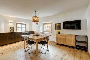 a kitchen with a table and chairs and a tv at Stube Biohof Oberzonn in Kastelruth