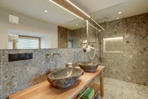 a bathroom with two sinks on a wooden counter at Stube Biohof Oberzonn in Kastelruth +24 photos