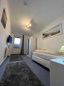 Schlafzimmer mit einem Bett, einem Schreibtisch und einem Fenster in der Unterkunft Haus Richter in Westerland