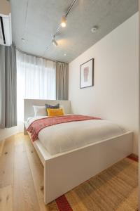 a white bed in a bedroom with a window at Dash Living Kagurazaka in Tokyo