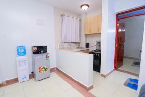 cocina con nevera blanca y fregadero en Garden City furnished apartment, en Nairobi