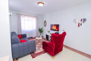 sala de estar con sofá y silla roja en Garden City furnished apartment, en Nairobi
