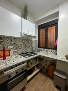 a kitchen with white cabinets and a stove top oven at Apartamento Irene 1 in Caravaca de la Cruz