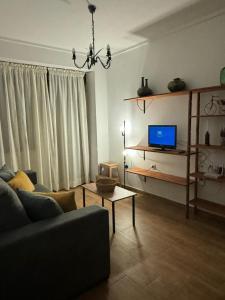 a living room with a couch and a tv at Apartamento Irene 1 in Caravaca de la Cruz