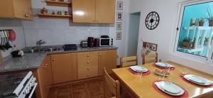 uma cozinha com uma mesa com dois pratos e copos em Casa Au Bonheur des Randonneurs em Ponta do Sol