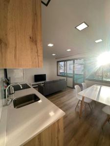 a kitchen with a sink and a table with chairs at Apartamento a 1 minuto de la playa in Castelldefels