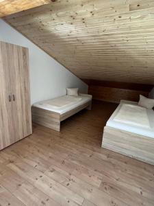 two beds in a room with a wooden ceiling at Haus Kärnten in Döbriach