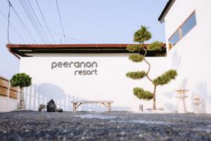 a bench in front of a building with a sign that reads premier resort at Peeranon Resort in Ban Nong Khiam