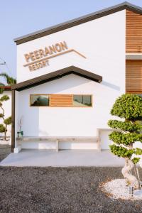 a white building with a sign on it at Peeranon Resort in Ban Nong Khiam