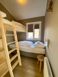 Dormitorio pequeño con litera y escalera en Tinyhouse Grasmus, en Nunspeet