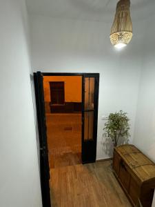 una stanza con una porta, un tavolo e un lampadario a braccio di Apartamento Irene 2 a Caravaca de la Cruz