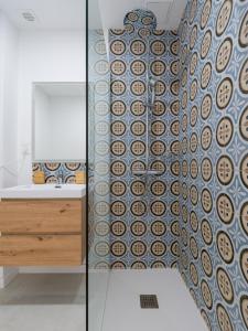 baño con pared de cristal con lavabo y espejo en HomeForGuest Estudio Brisa Canteras con terraza, en Las Palmas de Gran Canaria