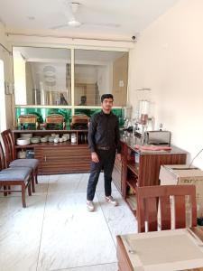 a man standing in front of a counter in a kitchen at Astra Luxury Rooms and Cafe in Varanasi