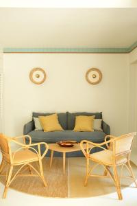 a living room with a couch and two chairs at Hotel des Dunes in Cap-Ferret