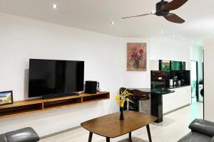 a living room with a flat screen tv on a wall at Peacefully Rawai 3 Bedrooms Pool Villa in Rawai Beach