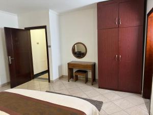 a bedroom with a bed and a mirror and a table at Road Map Guest House in Addis Ababa
