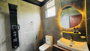 uma casa de banho com um lavatório, um espelho e um WC. em Beverly Beach Mirissa em Mirissa