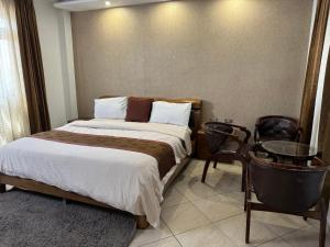 a bedroom with a bed and a table and chairs at Road Map Guest House in Addis Ababa
