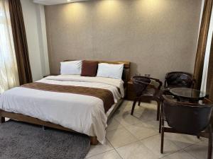 a bedroom with a bed and a table and chairs at Road Map Guest House in Addis Ababa
