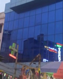 a glass building with a reflection of a city at Jupiter Beach Resort , Puri in Puri