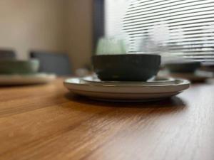 a plate on a wooden table with two cups on it at Riverview Caravan in Briery Yards