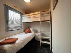 a bedroom with two bunk beds and a window at Riverview Caravan in Briery Yards