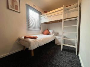 a bedroom with two bunk beds and a window at Riverview Caravan in Briery Yards