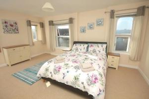 a bedroom with a bed and two windows at 28A Benedict Street in Glastonbury