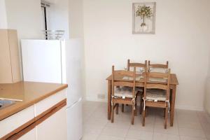 a kitchen with a table and chairs and a refrigerator at 28A Benedict Street in Glastonbury