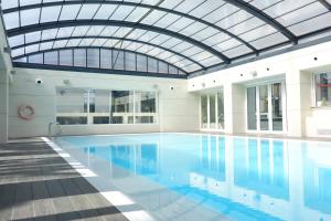 Palau de Congressos Great Stay Room في فالنسيا: مسبح داخلي بسقف زجاجي ومسبح