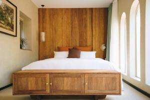 Schlafzimmer mit einem großen Bett mit einem Kopfteil aus Holz in der Unterkunft 禾煦的家-和煦 HX house in Qingdao