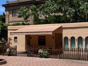 ein kleines Haus mit einem Zaun und einem Gebäude in der Unterkunft 禾煦的家-和煦 HX house in Qingdao