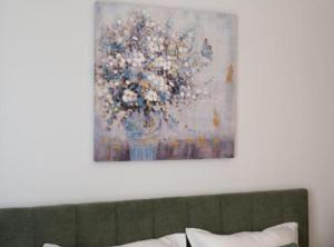 una pintura de un jarrón de flores en una pared en Apartment Kona, en Ivanja Reka
